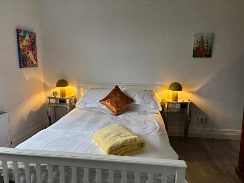 a white bed with two lamps on two tables at Boutique Rooms at The Ellesmere in Hornsea