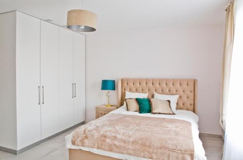 a bedroom with a large bed with white cabinets at Elegant City Center Apartment 7A in Krakow