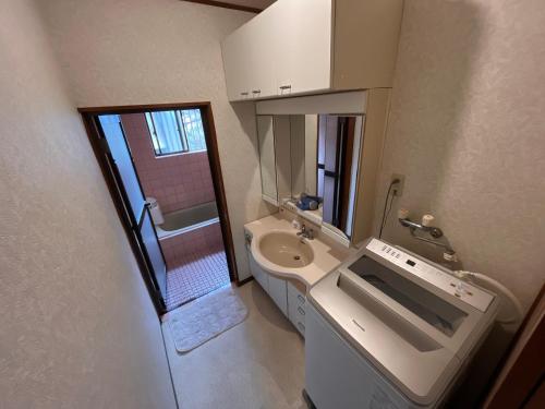 ein kleines Badezimmer mit Waschbecken und Toilette in der Unterkunft MaruHouse in Nachikatsuura