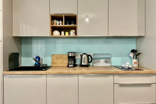 a kitchen with white cabinets and a counter top at Villa Marie 2 Appartement tout confort climatisé 1 chambre proche plage in Le Grau-du-Roi