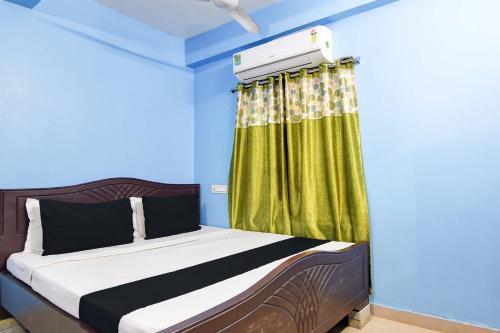 a bedroom with a bed with a green curtain at HOTEL O RAHAN APPARTMENT in New Town