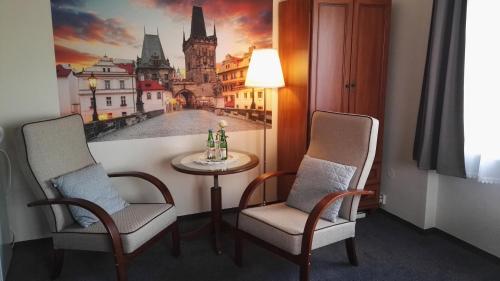 a room with two chairs and a table with a painting at Pension Villa Marit in Prague