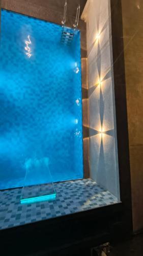 a large swimming pool in a bathroom with lights at Mist Villa in Igatpuri