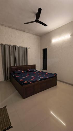 a bedroom with a bed and a ceiling fan at Mist Villa in Igatpuri