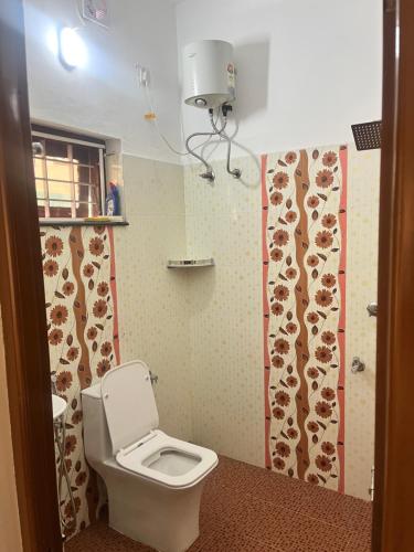 a bathroom with a toilet and a curtain with cows on it at MR Homes in Cochin