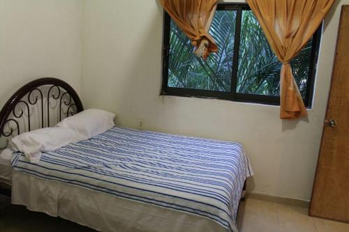 a bed in a bedroom with a window at Family villa in Tequesquitengo