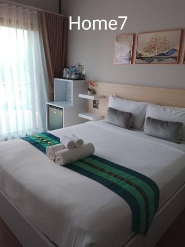 a bedroom with a large bed with towels on it at Two Tree Cafe At Suanmuangthong