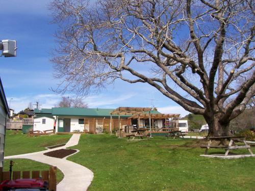 a park with a tree and a building at Waitomo TOP 10 Holiday Park in Waitomo Caves