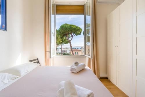 a bedroom with a white bed and a window at Ca'Mea 2 Vista Mare, vicino alla pista ciclabile in Imperia