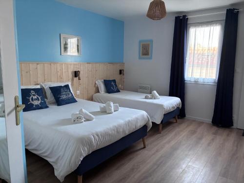 two beds in a room with blue walls at Hotel Marjolaine in Roullet