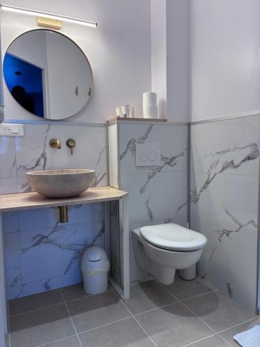 a bathroom with a sink and a toilet and a mirror at Hotel Marjolaine in Roullet