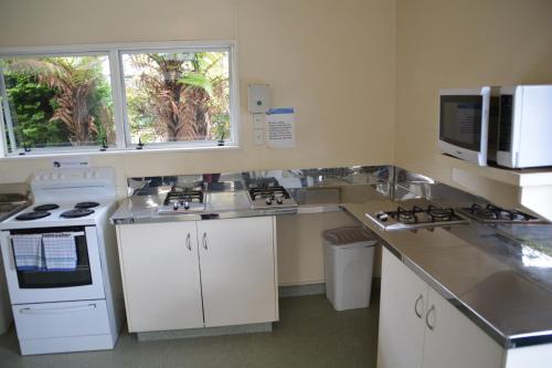 a kitchen with white appliances and a counter top at Waitomo TOP 10 Holiday Park in Waitomo Caves