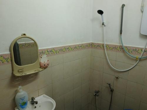 a bathroom with a sink and a mirror and a shower at HOMESTAY TASNIM in Bentong