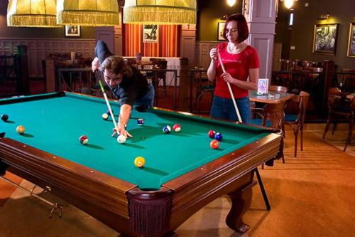 a woman and a boy playing a game of pool at Penzion Bowling in Liptovský Mikuláš
