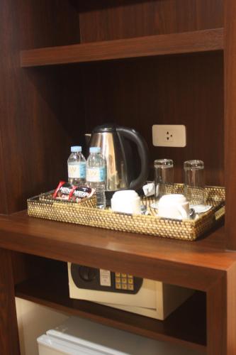 a coffee maker on top of a microwave on a shelf at Kew Hotel Tagbilaran in Tagbilaran City