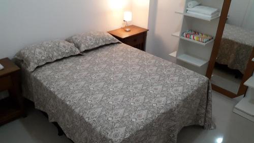 1 dormitorio con 1 cama y 1 mesa con lámpara en VG Fun Residence - Fortaleza Flats, en Fortaleza