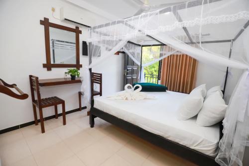 a bedroom with a bed with a canopy at Yala Elegant Hotel in Tissamaharama