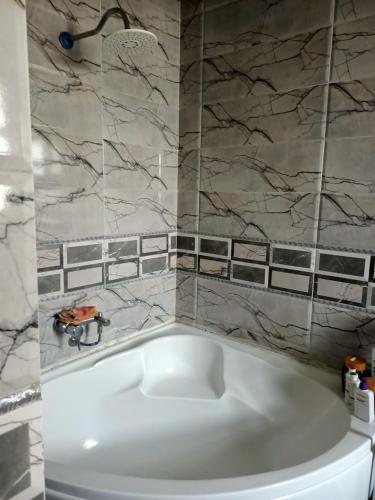 a white bath tub in a bathroom with marble walls at فيلا in Sheikh Zayed