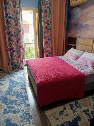 a bedroom with a bed with a red blanket at فيلا in Sheikh Zayed