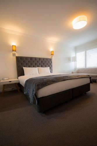 a bedroom with a large bed in a room at Quays Hotel in Batemans Bay