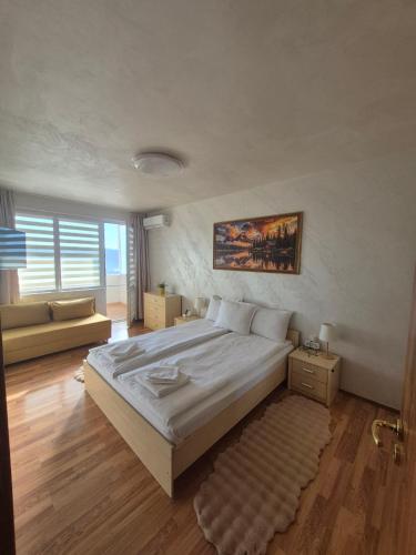 a bedroom with a large bed and a couch at Апартаменти Ванкови in Veliko Tŭrnovo