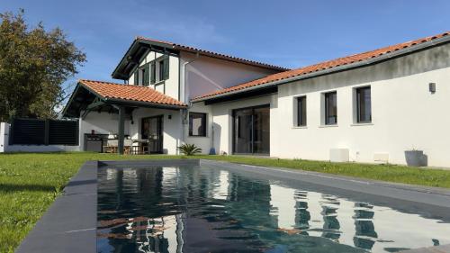 a house with a swimming pool in front of a house at Villa Haizea proche Bidart in Ahetze