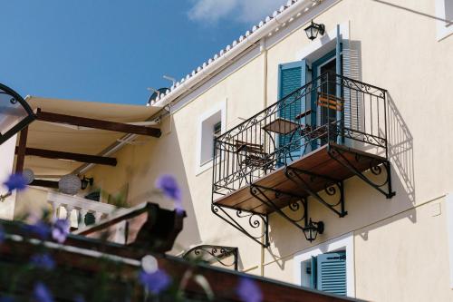 a building with two balconies and a blue door at Guesthouse Niriides in Spetses