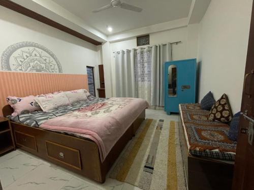 a bedroom with a bed and a chair in it at Lotus home in Jaigaon