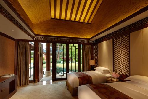 a bedroom with two beds and a large window at Imperial Springs in Conghua