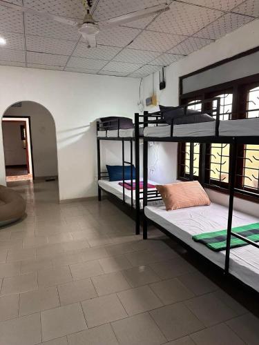 a room with three bunk beds in a room at R BackPacker Hostel in Ahangama
