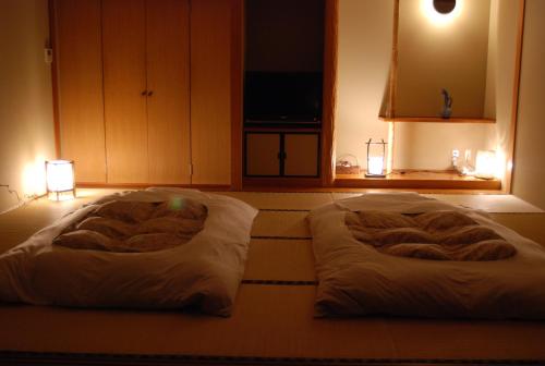 two beds sitting on the floor in a room at Ryokan Fukuzen in Shibukawa
