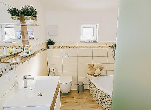 a bathroom with a tub and a toilet and a sink at Ferienwohnung Schusternagerl in Simbach