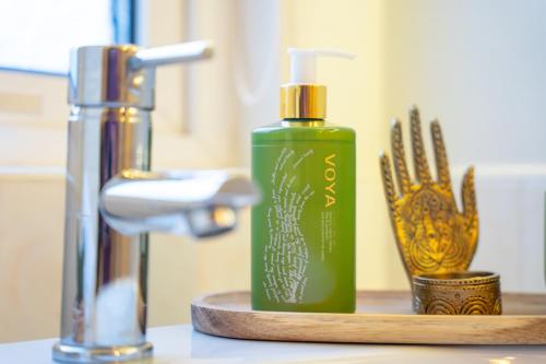 a green bottle of soap on a counter next to a sink at The Links Suites in Newcastle