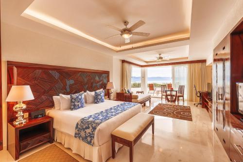 a bedroom with a bed and a living room at Grand Miramar All Luxury Suites & Residences in Puerto Vallarta