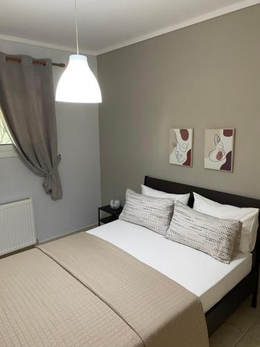 a bedroom with a bed and a pendant light at Vereniki 1 in Kriopigi