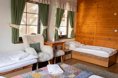 a bedroom with a bed and a chair and window at Villa Victoria Penzion in Liptovský Ján