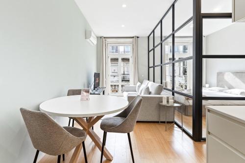 a living room with a white table and chairs at GuestReady - Modern Apartment in Bolhão in Porto