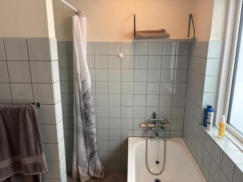 a bathroom with a tub and a shower curtain at Herning Nord - Tjørring Beds in Herning