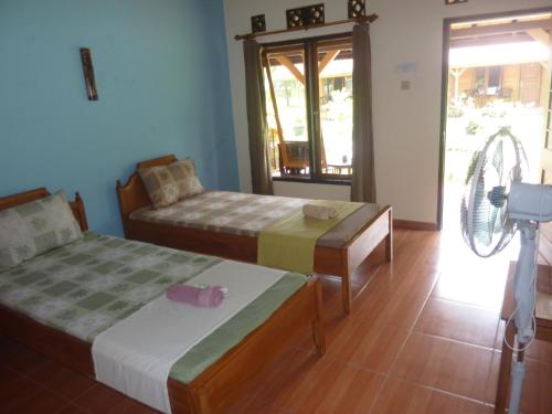 a room with two beds and a fan at Java Lagoon in Pangandaran