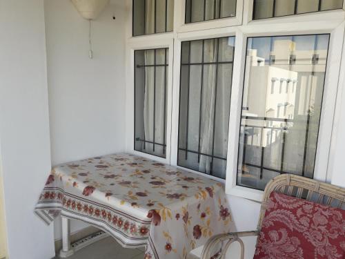 a table sitting on a balcony next to a window at Bano Tourist Residence - 650 meters from Grand Bay Beach in Grand-Baie