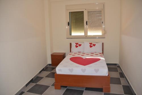 a bedroom with a bed with a heart pillow at Hotel Restorant Panorama in (( Bashtovë ))