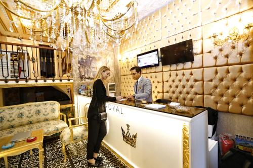 a man and a woman standing at a counter at Diamond Royal Hotel in Istanbul