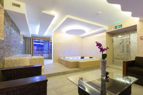 uma sala de estar com uma banheira e uma mesa em Hotel City Savoy em Belgrado