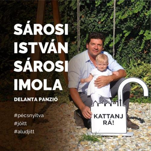 a man holding a baby in front of a cake at Delanta Panzió in Pécs