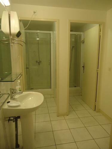 une salle de bain blanche avec un lavabo et une douche dans l'établissement Domaine de la Pinsonnière, à La Livinière