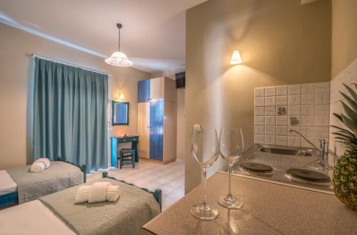 a kitchen with two wine glasses on a table at Nikos & Maria Studios in Laganas