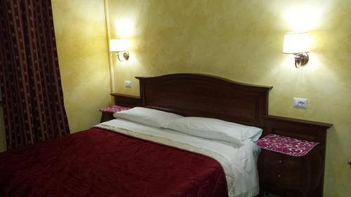 ローマにあるピタゴーラ B＆Bのベッドルーム1室(赤いシーツと白い枕のベッド1台付)