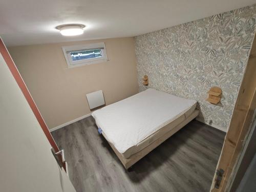 a small bedroom with a bed in a room at Chambre à louer in Bonnétable