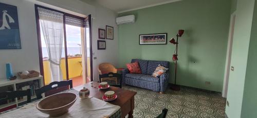 a living room with a table and a couch at Eremare Marinella in Marinella di Sarzana