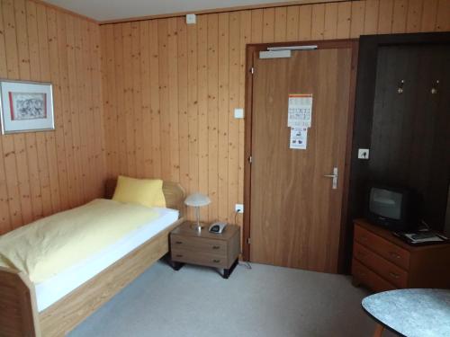 a small bedroom with a bed and a television at Hotel Bel-Air Eden in Grindelwald